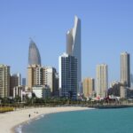 people on beach near high rise buildings during daytime