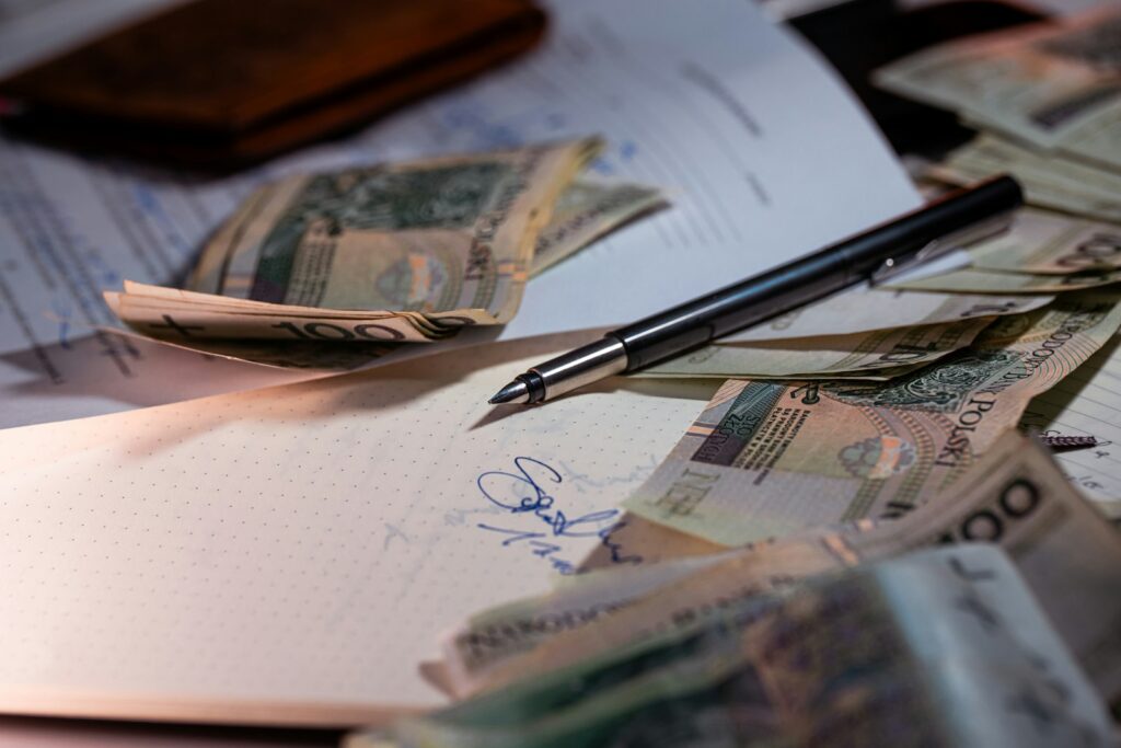 Pen and money scattered on documents