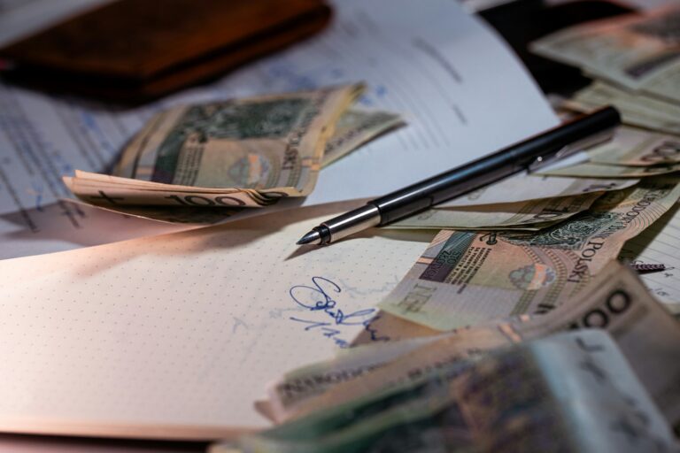 Pen and money scattered on documents