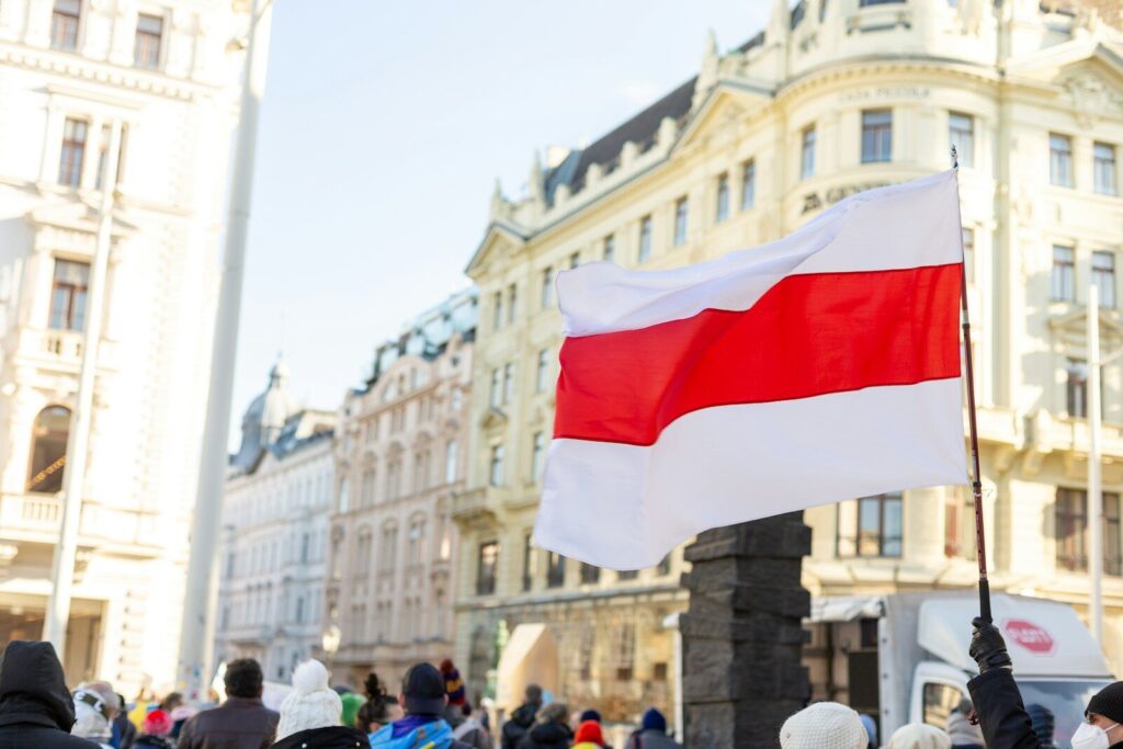 a crowd of people standing around a flag on a pole