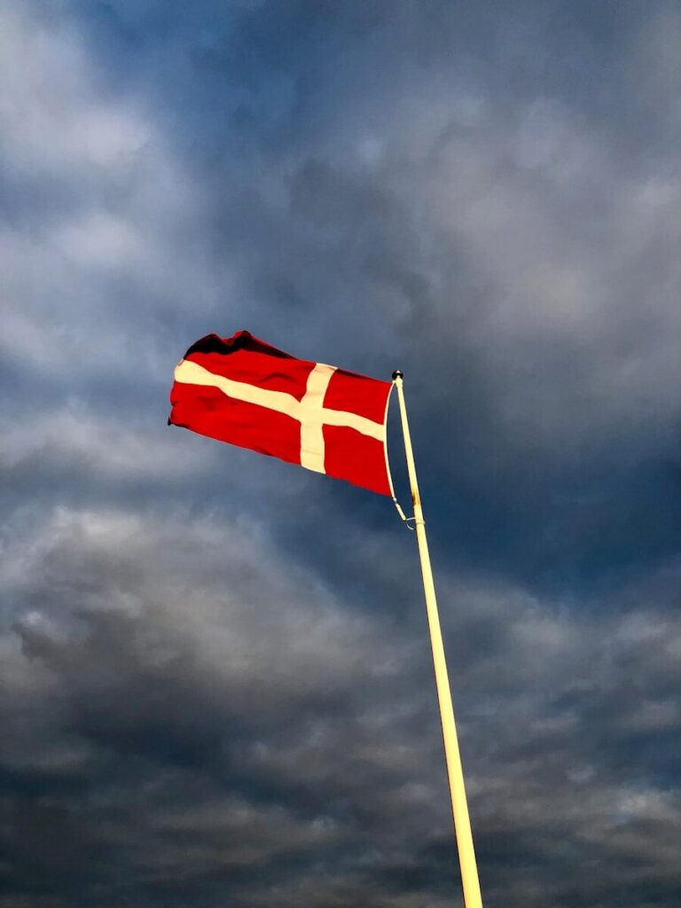 red and white cross flag on top of pole during day