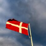 red and white cross flag on top of pole during day