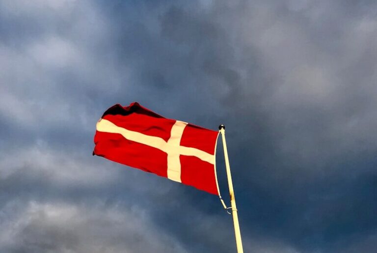red and white cross flag on top of pole during day