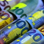 Rolled euro banknotes illuminated under uv light.