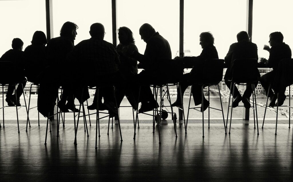 a group of people sitting at a table in front of a window