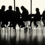 a group of people sitting at a table in front of a window